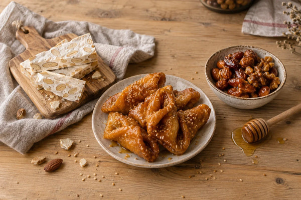 Selección de dulces navideños con miel: turrón, pestiños y frutos secos caramelizados.