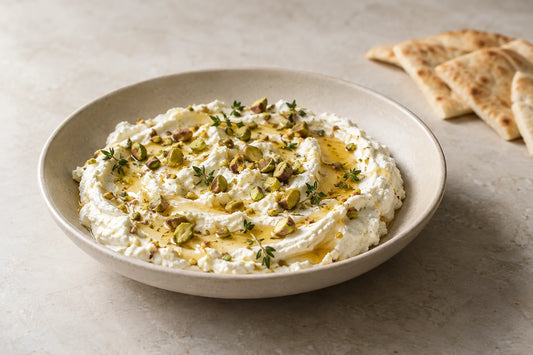 Feta batida con miel y pistachos tostados junto a pan pita