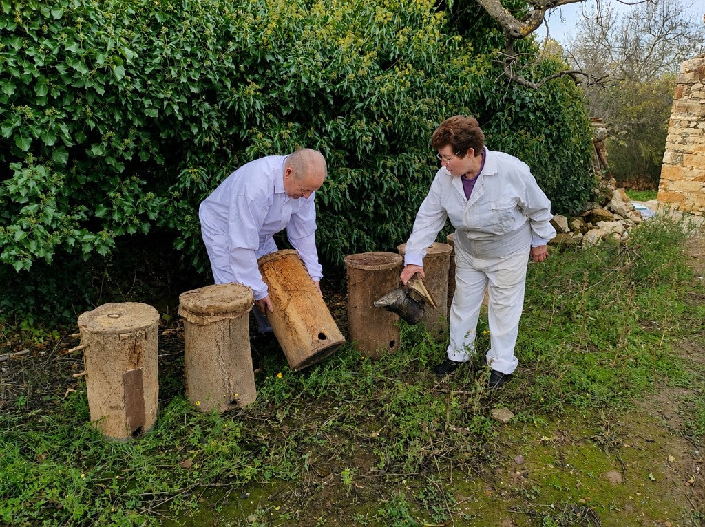 Francisco y Carmen junto a las colmenas tradicionales de corcho de la familia en Culla