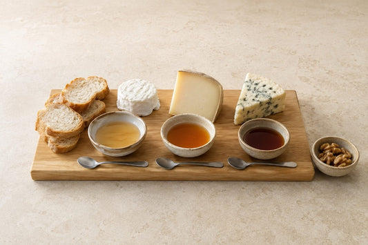 Tabla con queso fresco, semicurado y azul junto a tres muestras de miel de distinta intensidad
