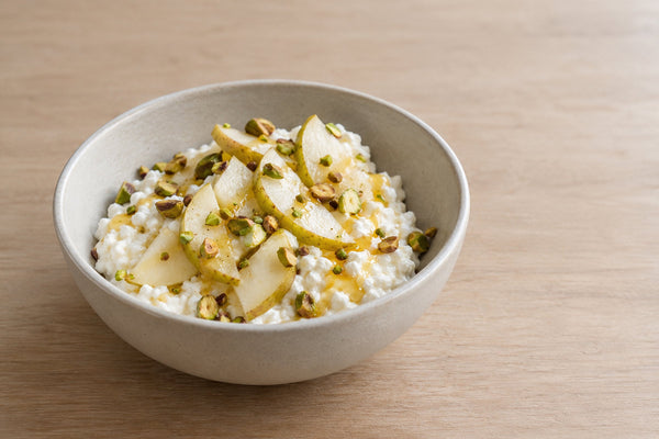 Bol de queso cottage con miel, pera y pistachos tostados
