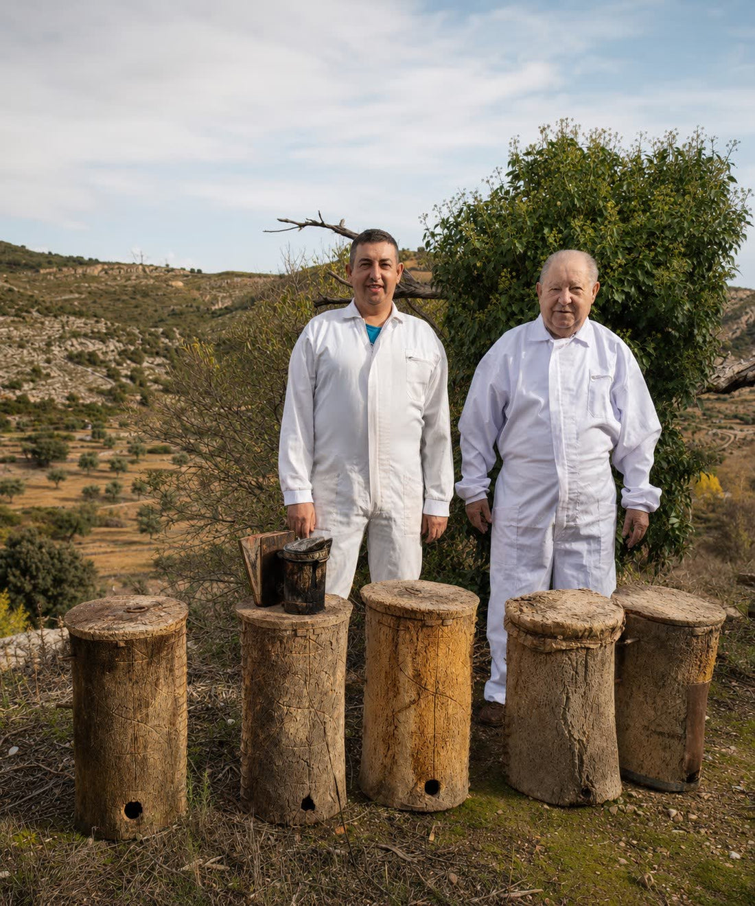 Padre y abuelo de Miel y Sabor junto a antiguas colmenas de corcho en Culla